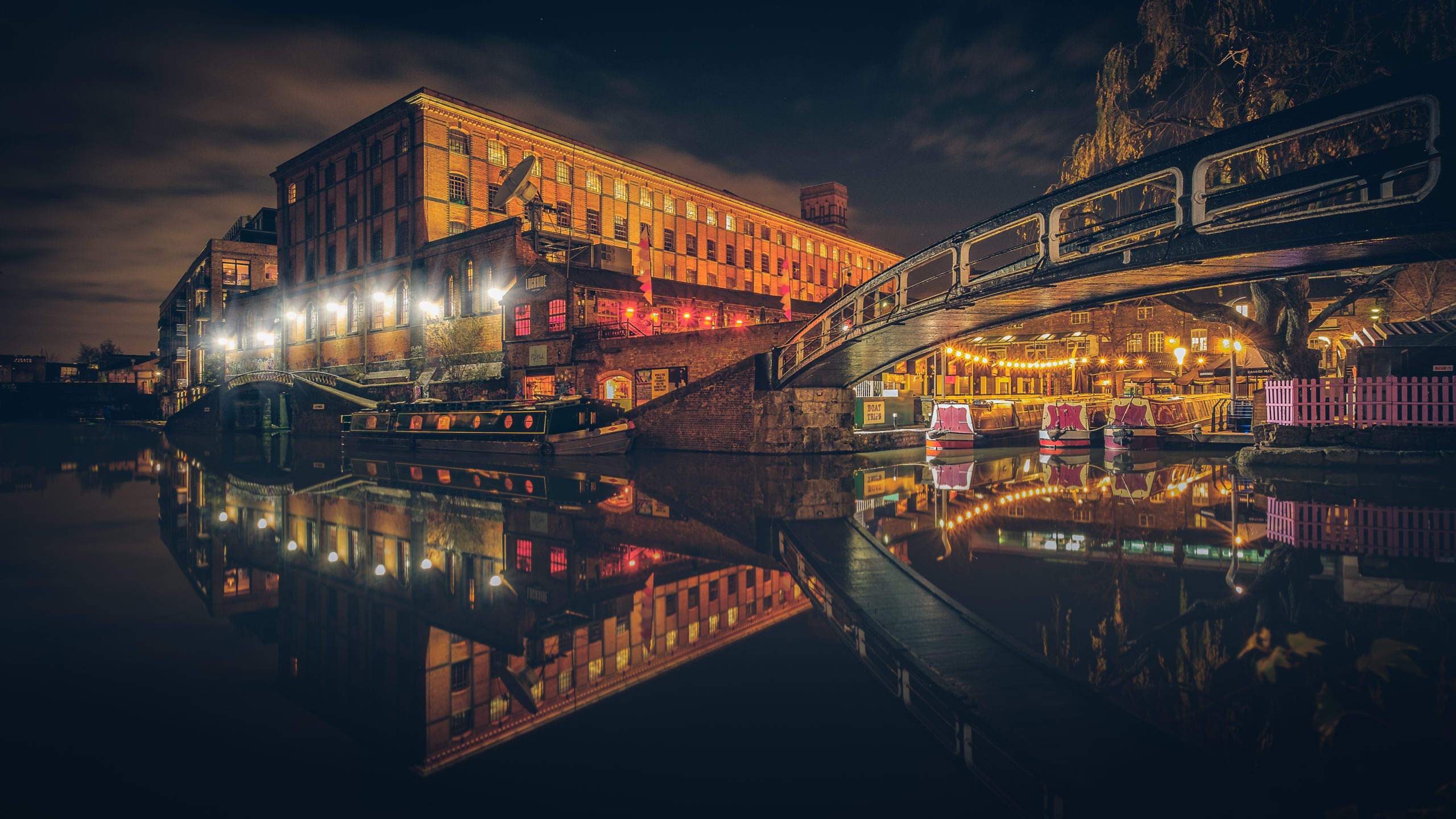 A photo of Camden Lock at night, with the reflection of the bridge on the canal