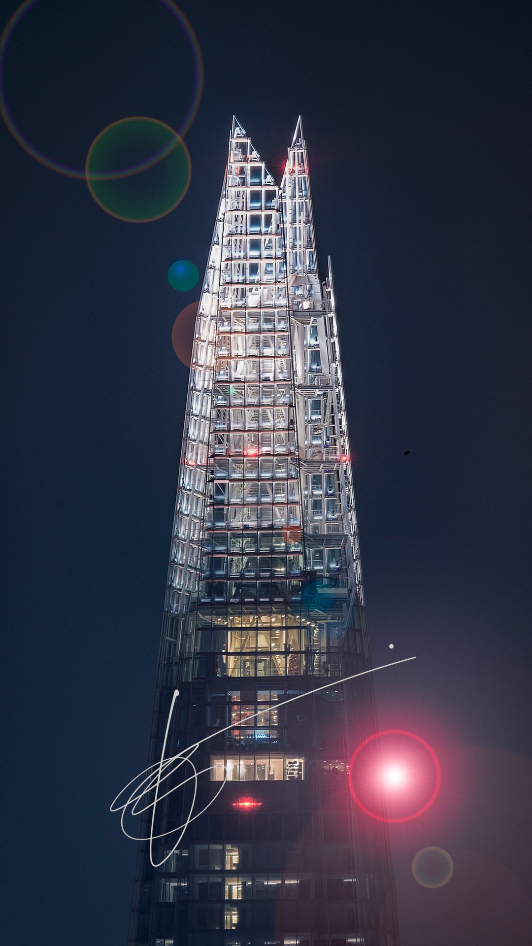 a close-up of the peak of the Shard in London at night