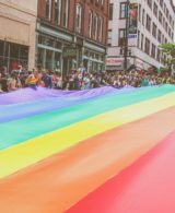 Giant rainbow flag carried by parade participants at London Pride