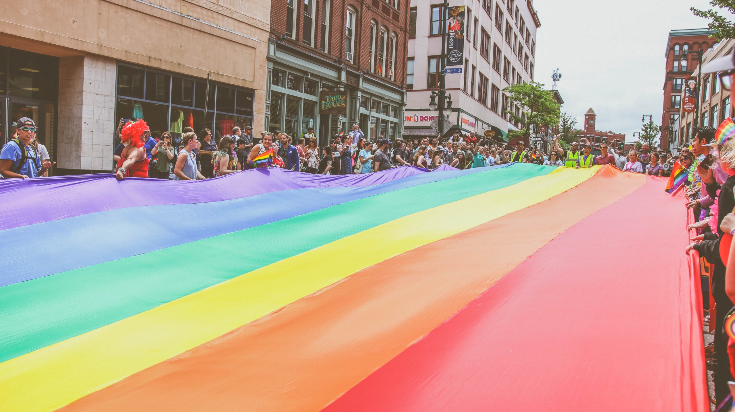 Giant rainbow flag carried by parade participants at London Pride