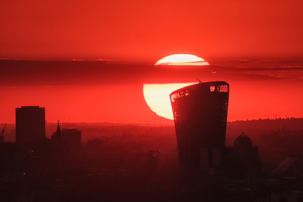 The sun setting behind the Sky Garden in Fenchurch Street, London, shot from over 10 miles distance